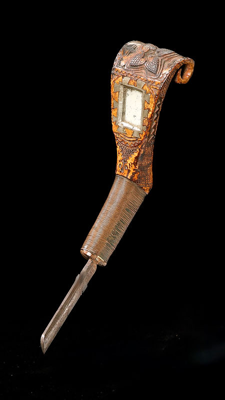 Full view of a historic Maliseet crooked knife from Maine or Canada, circa 1860-1880, featuring apple burl wood, mirror insert, lead inlays, and copper wire. Ex: Fred Giampietro and David Wheatcroft collections.