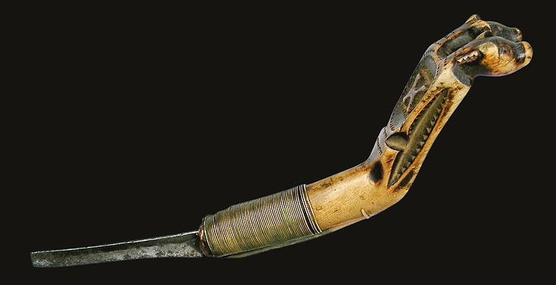 Full left-side view of a Maliseet double bear effigy crooked knife, exhibited at the Winter Antiques Show in New York City, 2008.