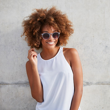 Femme aux cheveux bouclés et lunettes de soleil