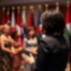 female protocol chief greeting guests at a formal gala and directing them