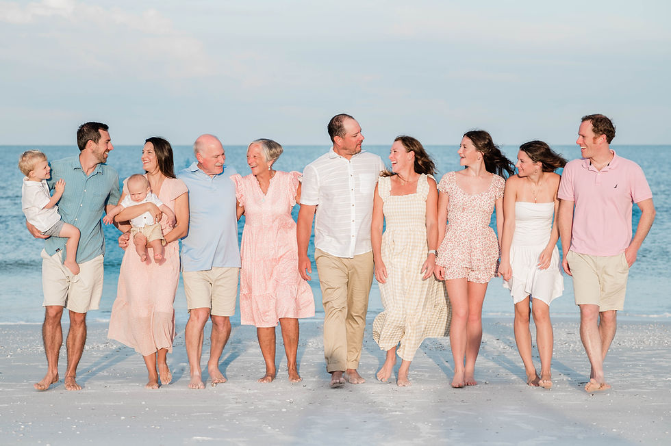 An extended family of 11 members smile while walking happily along Clearwater Beach.