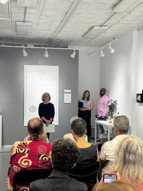 Greenberg speaking at opening reception of her exhibition "SERVED: Wrongful Convictions & the Death Penalty".  Guest speakers from the Innocence Project, exoneree Stefon Morant and attorney Hannah Fitzsimmons, waiting in the wings to speak. City Gallery, New Haven, CT 2025. 