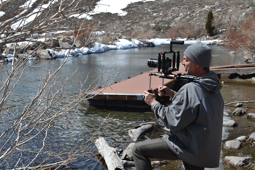 A cameraman looks out over a body of water