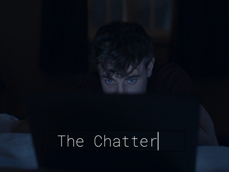 A man stares at a laptop in the dark