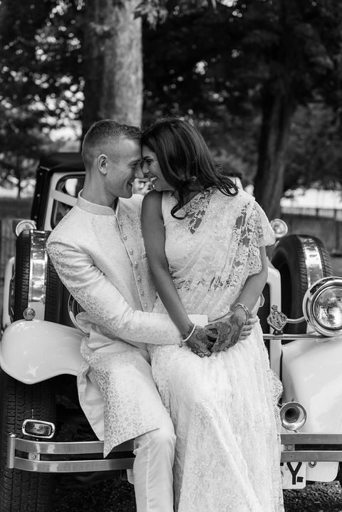 Bride and groom posing with the car in London