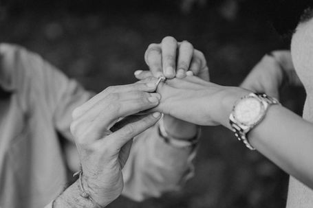 a man putting an engagement ring on a woman 's finger