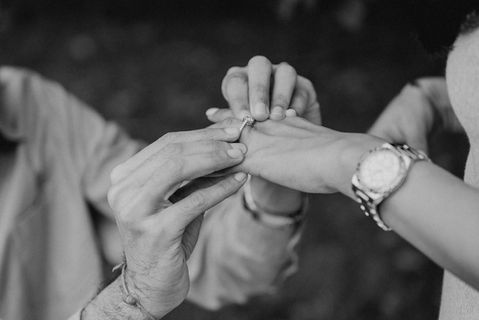 a man putting an engagement ring on a woman 's finger