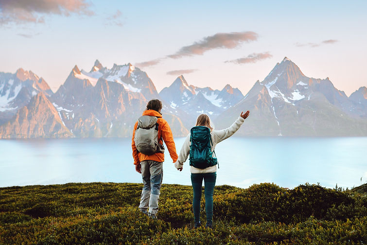 Couple in love hiking travel in Norway man and woman friends holding hands enjoying view,