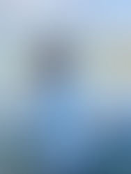 A woman in a blue shirt looking out over water from a boat.