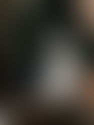 A white and black dog standing next to a person.