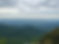 Scenic overlook of lush green mountains under a cloudy sky.
