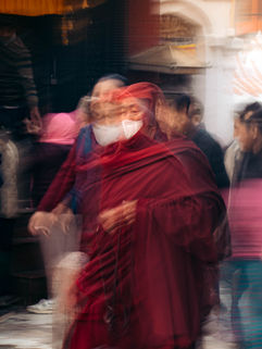 Buddhist practitioner, monk, wearing a PPE/covid mask walking around the Bouda stupa in Kathmandu, nepal. 