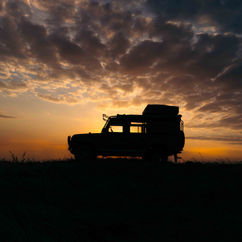 silhouette photo of a landrover in chyulu hills national park in Kenya during sunset. Black leopard 4x4 hire car
