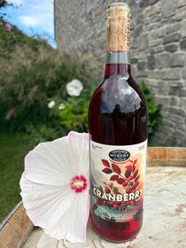 Cranberry wine on a barrel with a flower and brick background.
