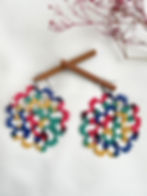 Dark horizon handmade tatting earrings by Knots to Node with multicolored threadwork on a white textured background
