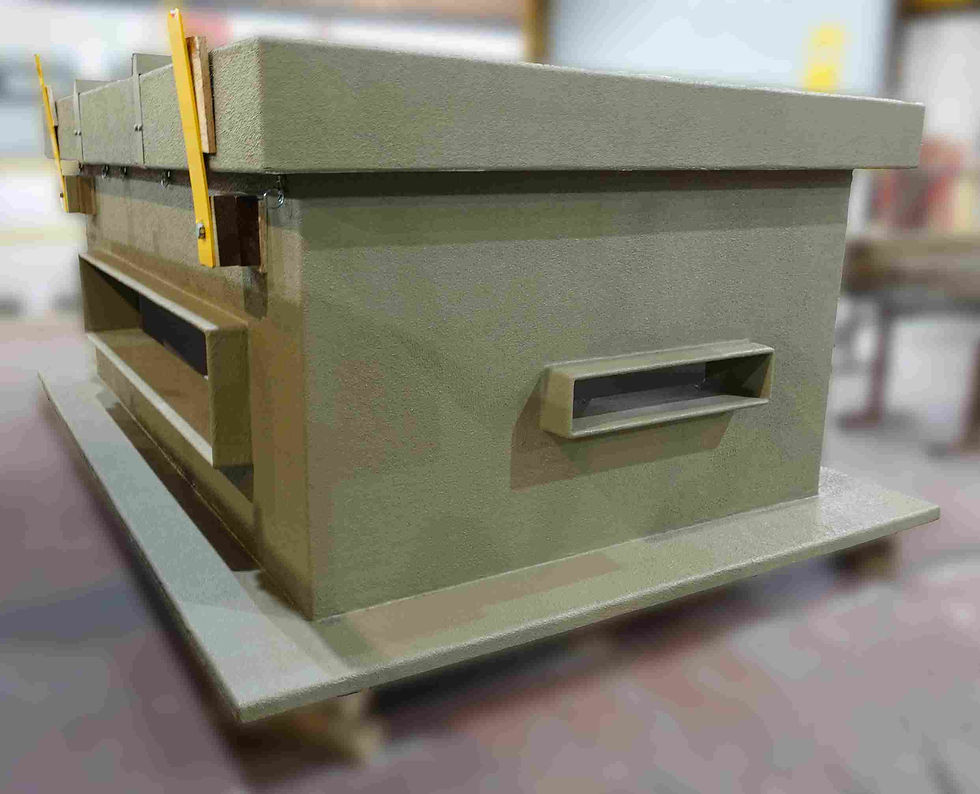 Large gray industrial roof enclosure - TopBox by Hill Grwp  with yellow handles and a metallic opening, in a warehouse setting. Blurred background.