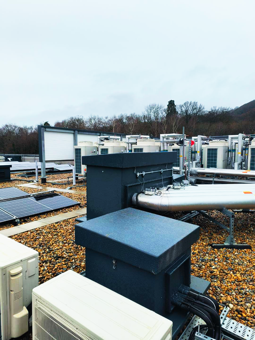 Black TopBox Roof Entry Systems installed in between solar panels on the top of the roof