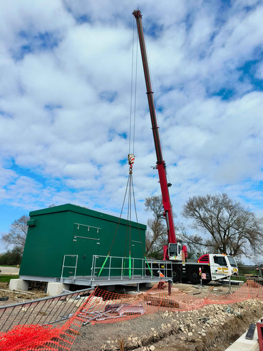 Metal Access platform is being installed by the crane next to the green substation kiosk