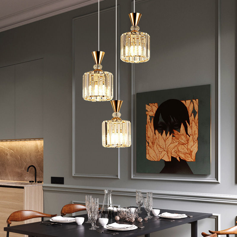 Three crystal pendant lights hanging over a dining table