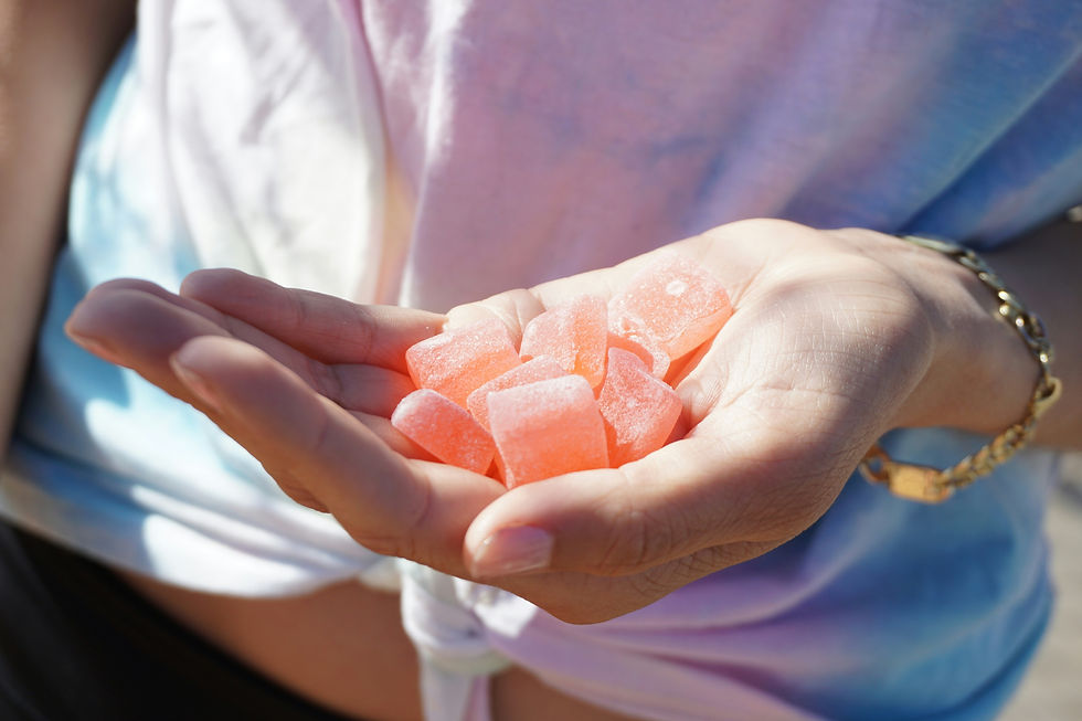 A woman holding a handful of THC Gummies.