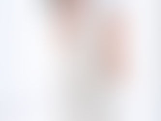 The Airport Arrival: A woman in a light beige FP Movement onesie over a white t-shirt, wearing white boots and taking a mirror selfie.