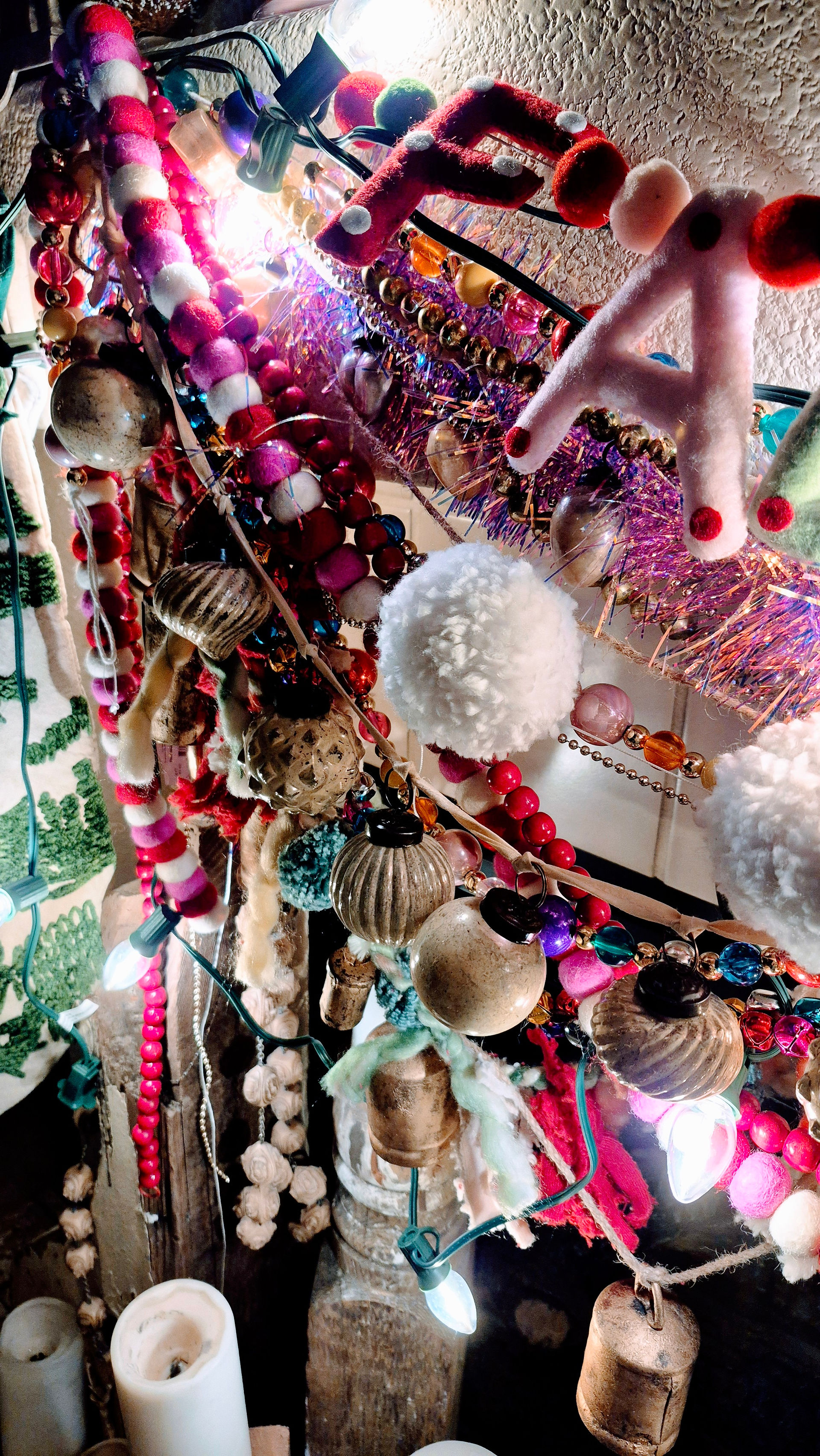 Pom-pom and cable knit Christmas stockings hanging on a neutral mantel with soft lights.