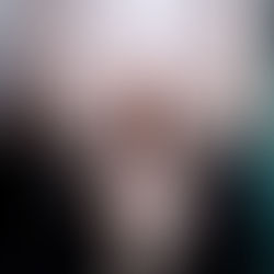 Ali posing in a boho-western style cream-colored jumpsuit and straw hat, showcasing how long hair extensions complement a full-length silhouette against patterned wallpaper.