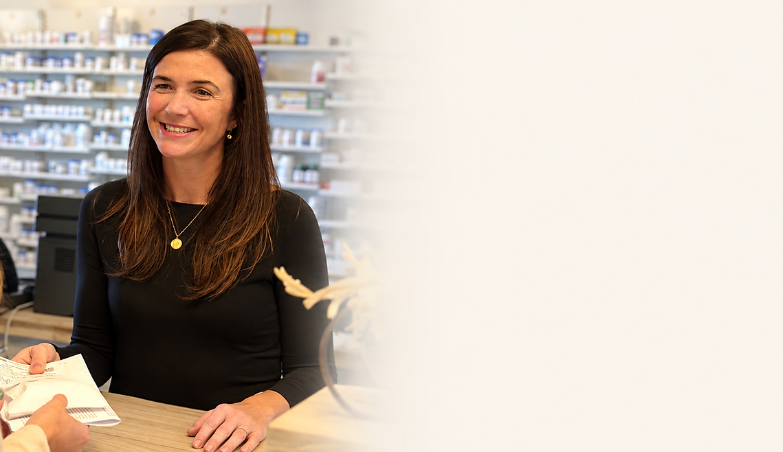 Smiling pharmacy team with warm cream space.png