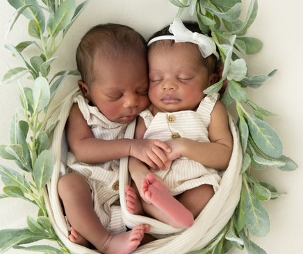 African American newborn twins resting together during a studio session by Suzi Brown Photography