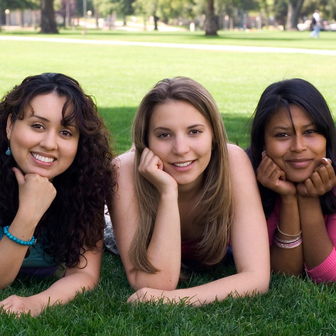 Three women of different racial ethnicities together laying on the ground