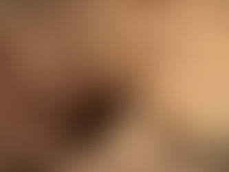 A rugged, rocky canyon with an open cave entrance, featuring sandy hues and sparse vegetation.