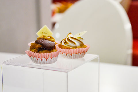 Organizza dolci e pasticcini su display a tavolino in plexiglass.