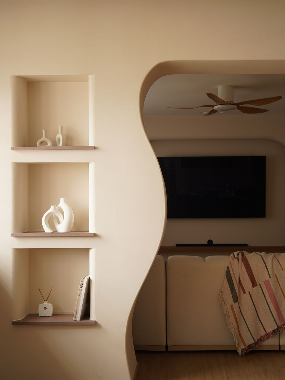 A wavy partition at the entrance; customised wall niches add character to the space.