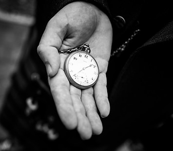 A groom holding a pocket watch.