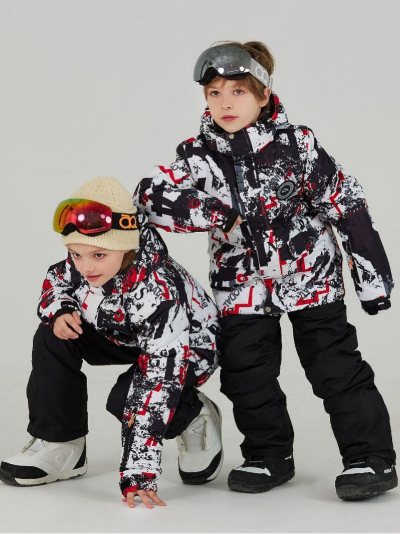 Thumbnail: 2人の子供が雪の中でスキーウェアを着ている、カラフルなデザインのジャケットとパンツ