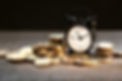 money background, coins and alarm clock on wooden table, concept of bank deposits, compoun