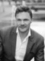 A black and white personal branding and dating profile portrait of a handsome 40-year-old man in Lon