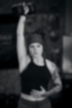 Liz owner of mountain edge performance using dumb bells to do a shoulder press
