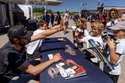 Drivers high fiving fans.