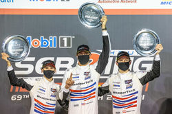 Drivers in victory plane standing together.