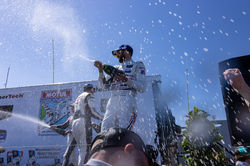 Spraying champagne on the crowd.