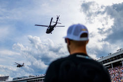 Helicopter overhead as SVG watches from the grid.