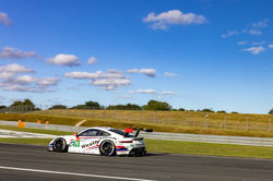 Porsche on a straightaway with the blue sky above.