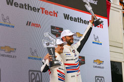 Drivers on the podium with trophies.