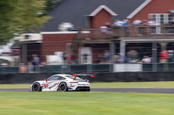 Porsche racing past fans.