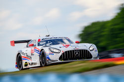 Mercedes coming up over a hill.