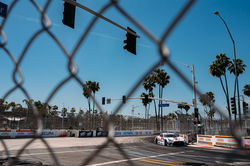 Mercedes through a chain link fence.