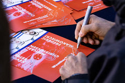Signing a flyer.