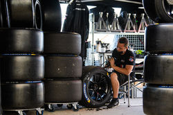 Crew member working on tires.