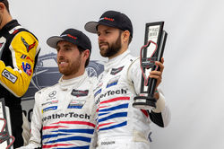 Drivers holding trophy.